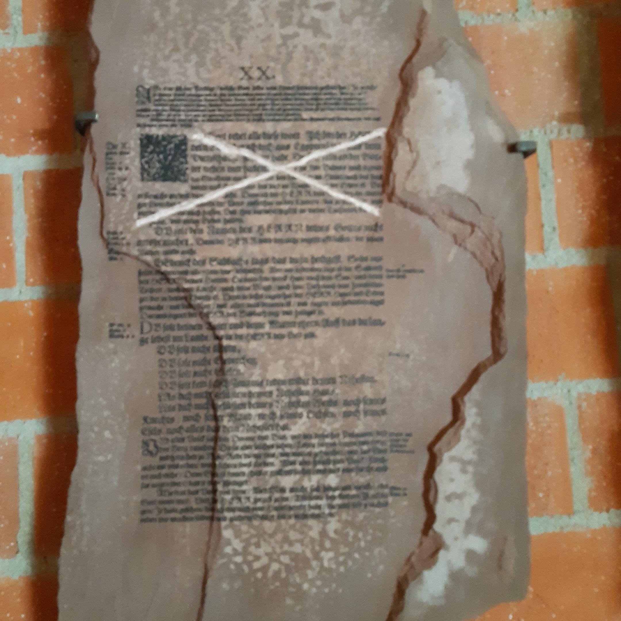 Steintafel mit Zehn-Gebote-Text aus der Lutherbibel, eine Passage durchgestrichen