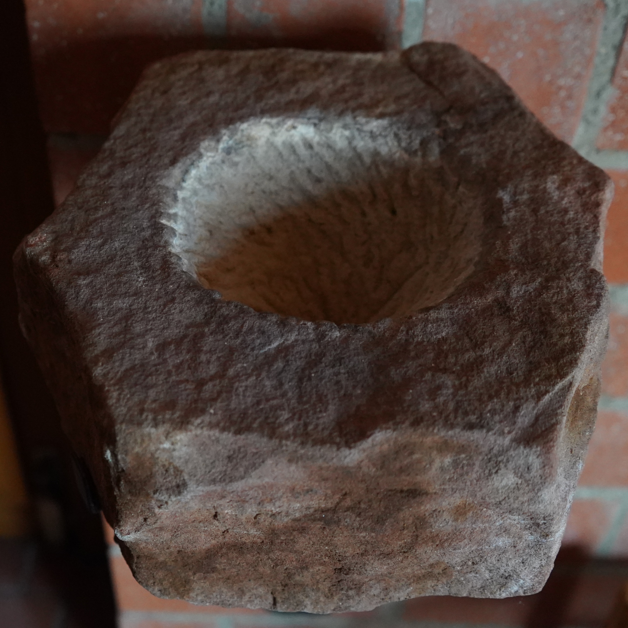 Grob behauener Stein mit runder Vertiefung für Weihwasser