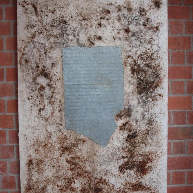 Leinwand mit zentraler Metalltafel und Keilschrift, von Sand umgeben