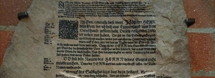 Steintafel mit Zehn-Gebote-Text aus der Lutherbibel, eine Passage durchgestrichen