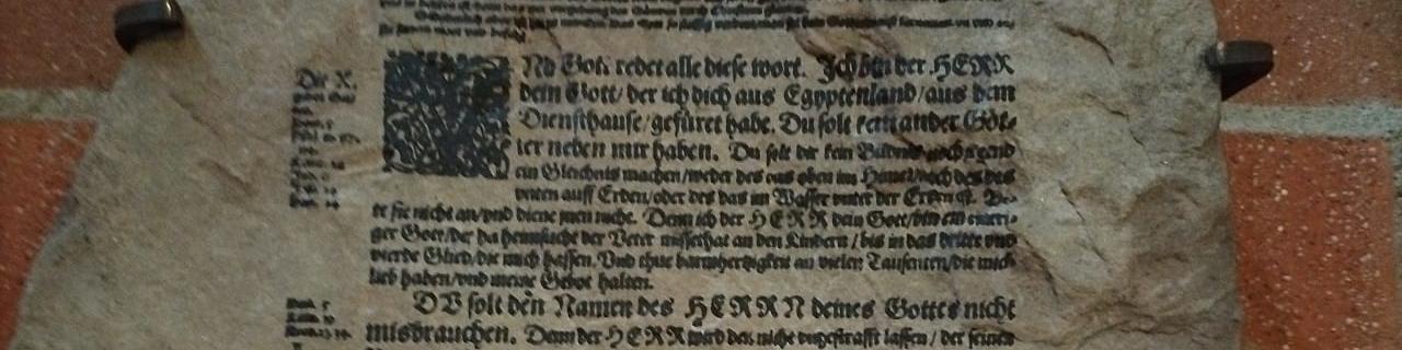 Steintafel mit Zehn-Gebote-Text aus der Lutherbibel, eine Passage durchgestrichen