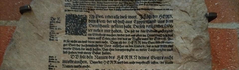 Steintafel mit Zehn-Gebote-Text aus der Lutherbibel, eine Passage durchgestrichen