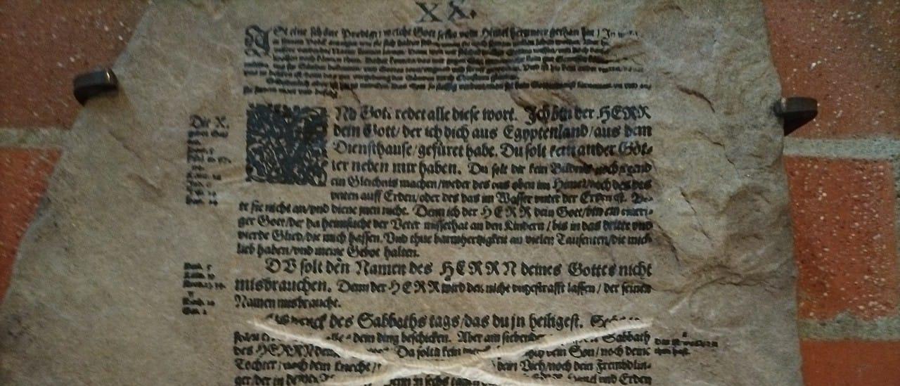 Steintafel mit Zehn-Gebote-Text aus der Lutherbibel, eine Passage durchgestrichen