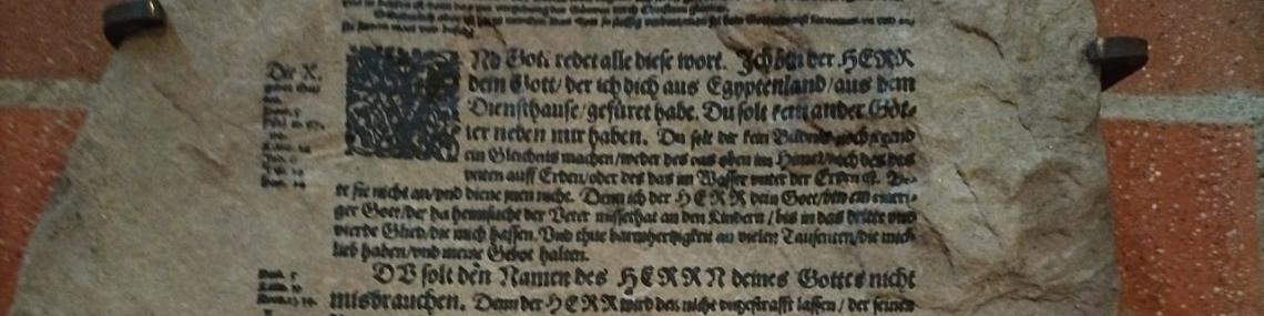 Steintafel mit Zehn-Gebote-Text aus der Lutherbibel, eine Passage durchgestrichen