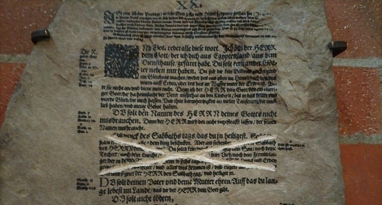 Steintafel mit Zehn-Gebote-Text aus der Lutherbibel, eine Passage durchgestrichen