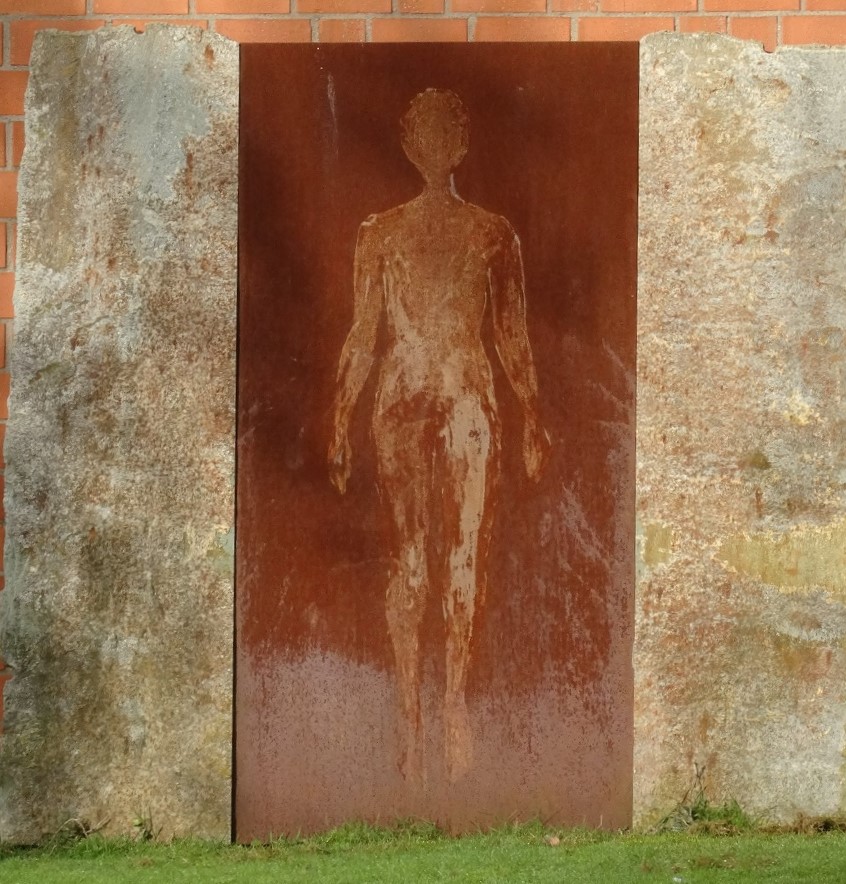 Rostige Metallplatte mit menschlicher Silhouette, eingefasst von zwei Steinplatten