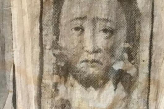 Ausschnitt: drei Gesichter in Tuch gedrückt